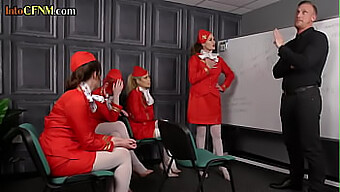 A group of female flight attendants in dominating roles pleasure a man's penis in a group orgy setting.